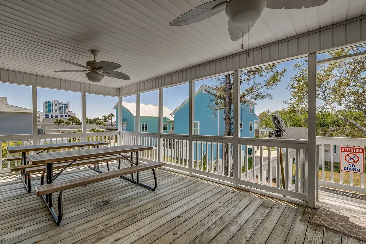 A spacious, sunlit dining room with multiple tables, ceiling fans, and large windows that fill the space with natural light. The scene evokes family meals, celebrations, and casual conversations, all within a welcoming and homey environment.